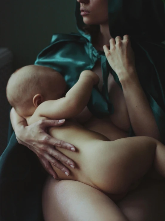 an image of a woman holding a baby that has it's  wrapped around