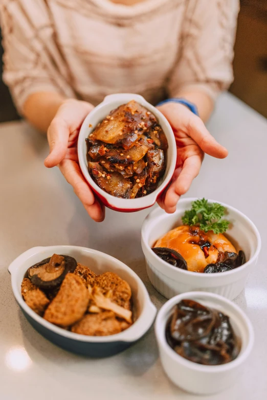 woman offering small portion of food from two bowls