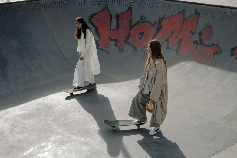 two young people skateboarding at a skate park