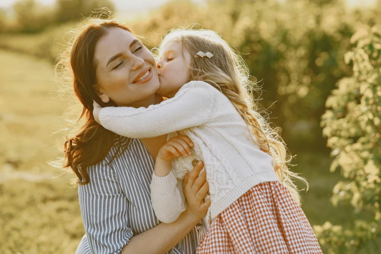 there is a woman and child kissing each other