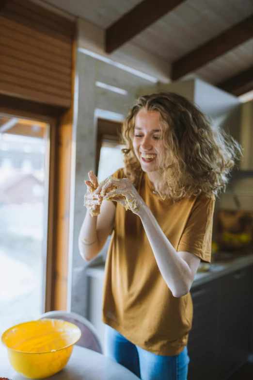 woman smiling, holding food item in her hands