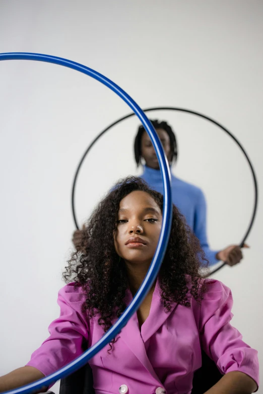 woman sitting in chair with hoop around her face with man standing behind