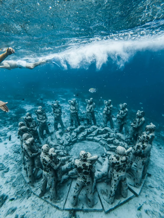 two people swimming near an underwater sculpture