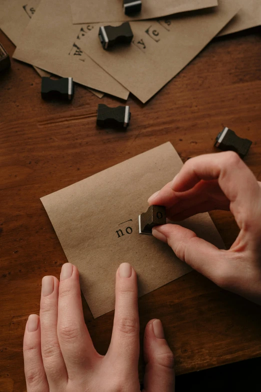 a person using a stamp to stamp letters on a piece of paper