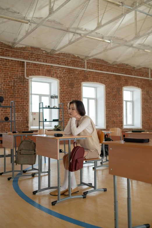 a woman leaning on desk next to another desk