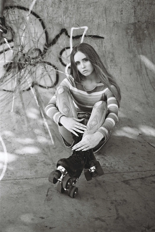 a young woman is sitting on her skateboard outside