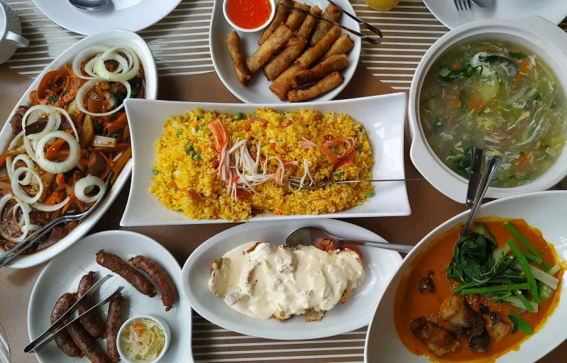 plates, dishes and forks are arranged on a table