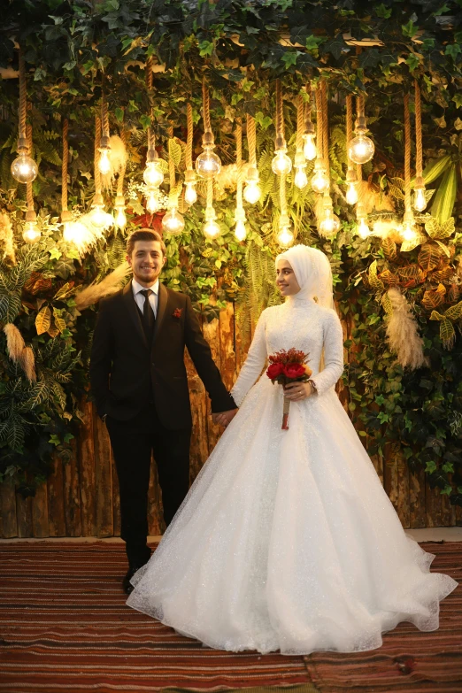 a couple dressed up for their wedding standing in front of flowers