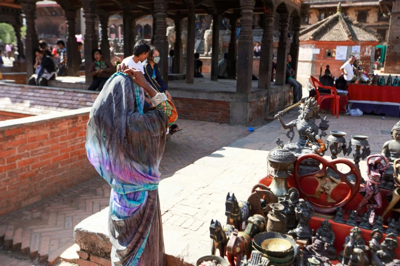 a woman walking down a street past a market place