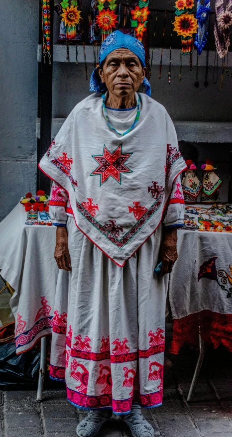 a woman standing in front of a table and an umbrella