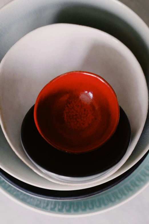 red bowl on white plate in center of gray bowl