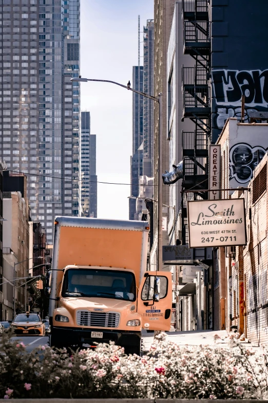 an orange truck in the alley between the buildings