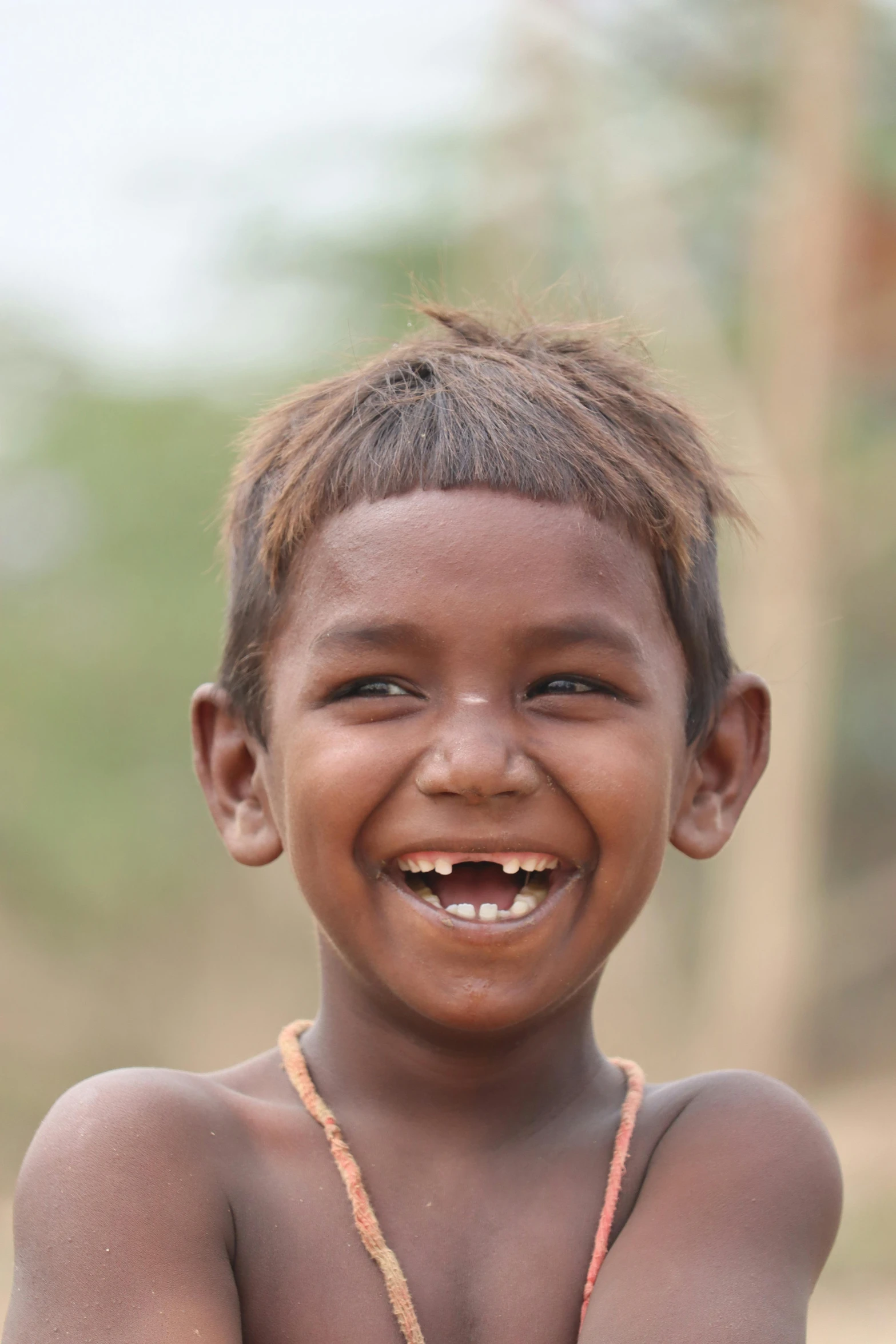 a child with  and a necklace smiling