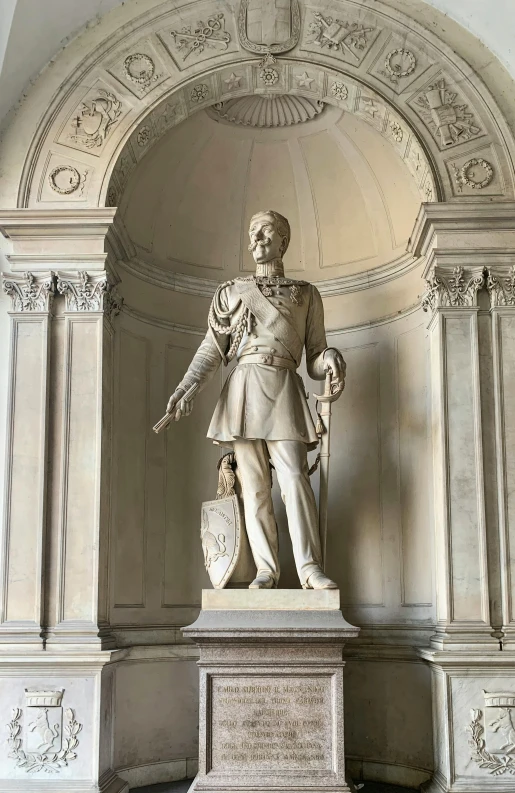 an old white statue with a shield on top