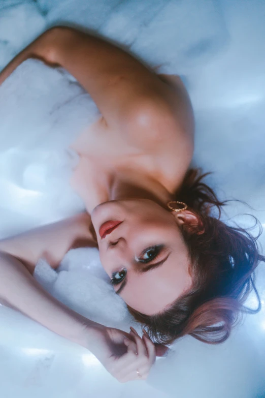 a woman is laying down in a bubble bath