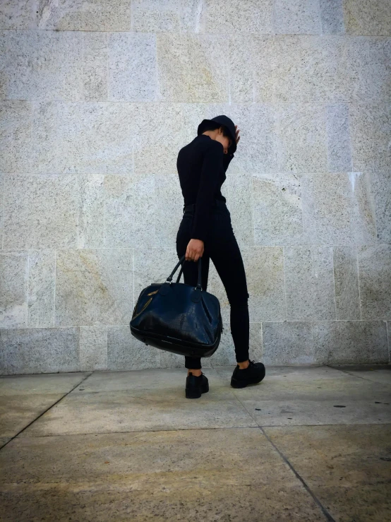 a person walking across the street carrying luggage