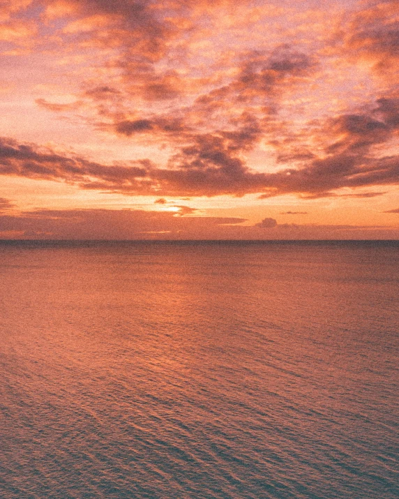 the sun is setting on the horizon of a body of water