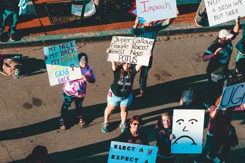 a group of people hold signs with faces