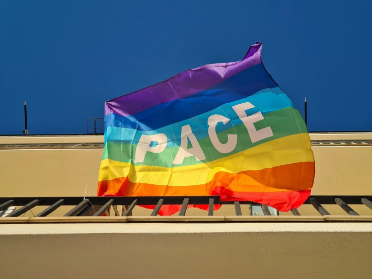 a gay pride flag flying outside with the word race written on it