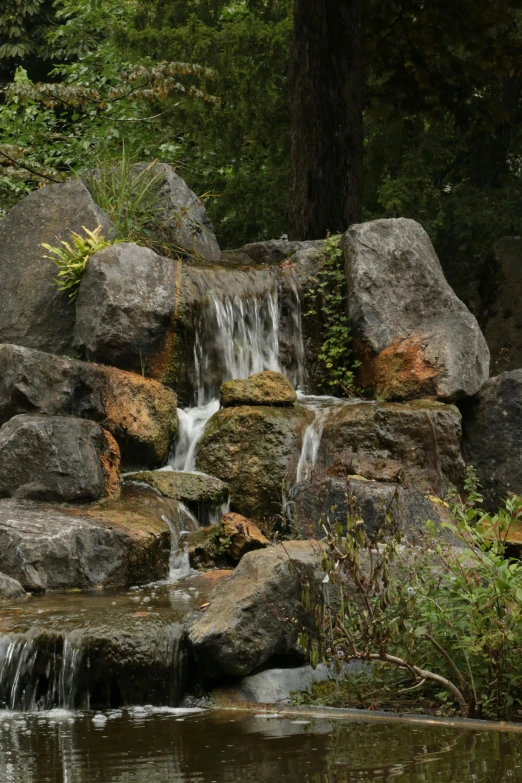 a view of an artificial waterfall with rocks surrounding