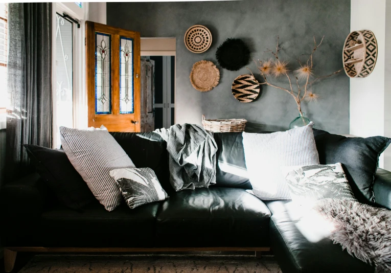 a black leather couch sitting next to a window