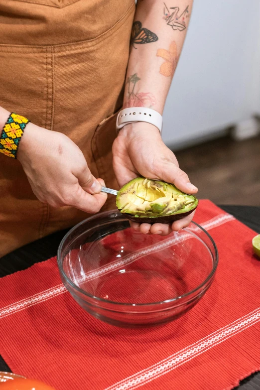 a person is  avocado into smaller portions