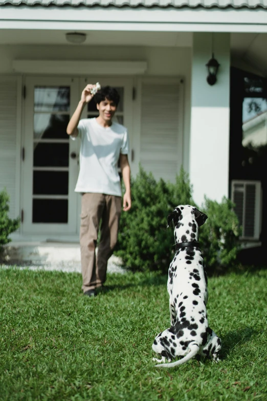 a man standing next to a dog and holding a bottle