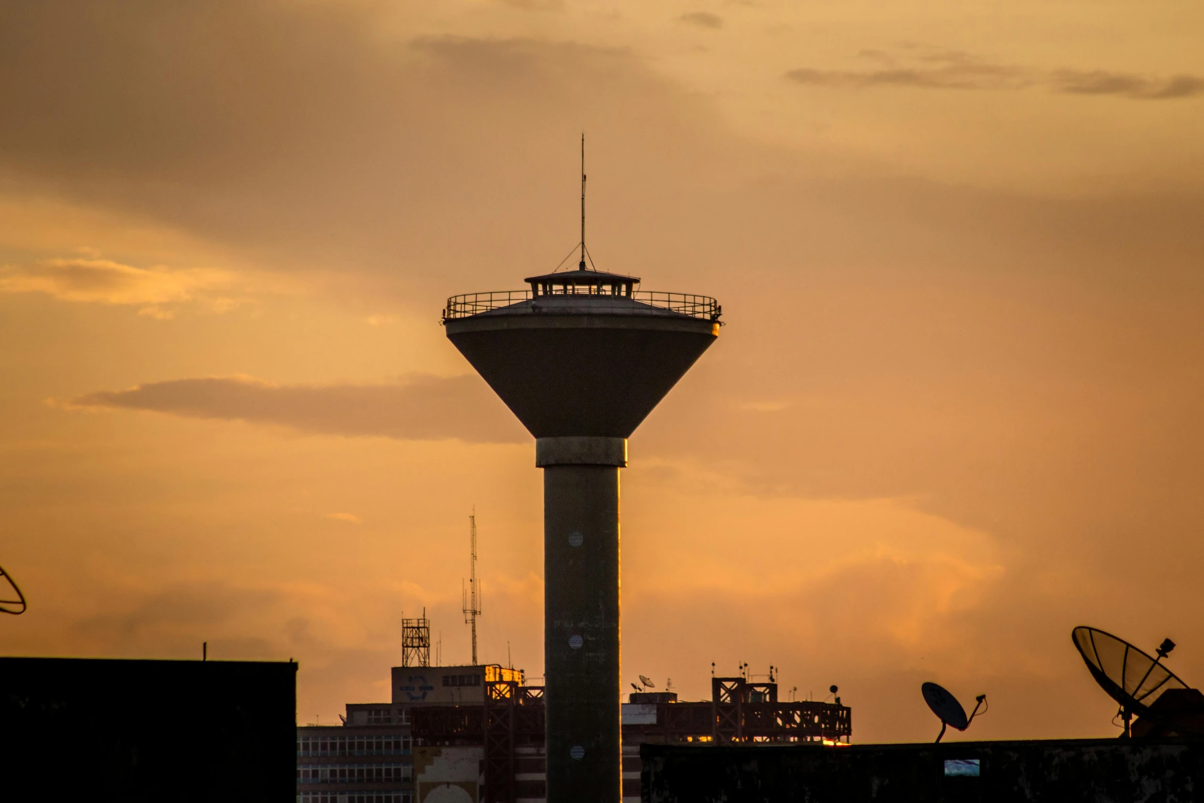 a tower is seen against a golden sunset