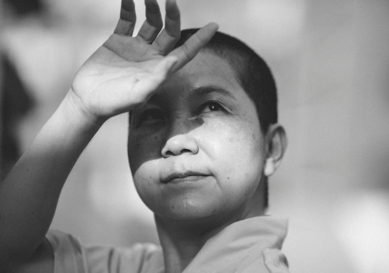 a child holding up the fingers to the top of his head