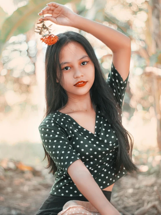a girl with long black hair and wearing a polka dot blouse