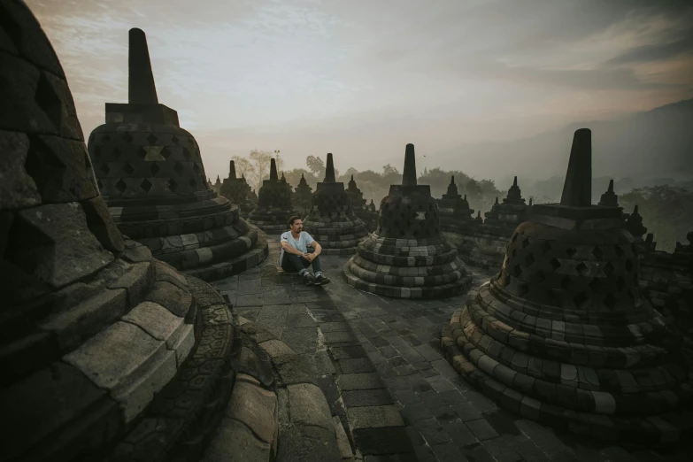 a man sits near a collection of buildings