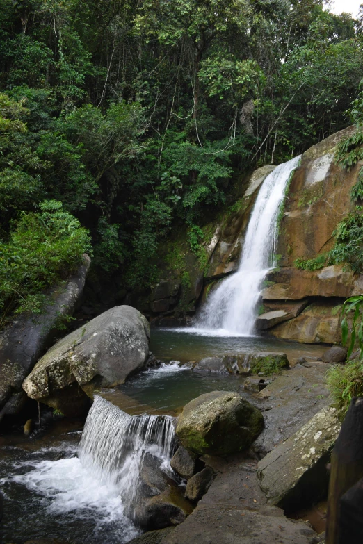 water cascading down a rocky face in front of a waterfall