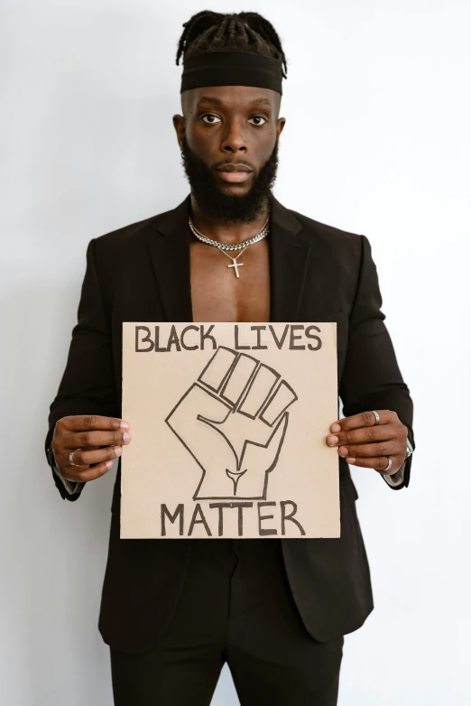 a black man holding up a sign that says, black lives matter