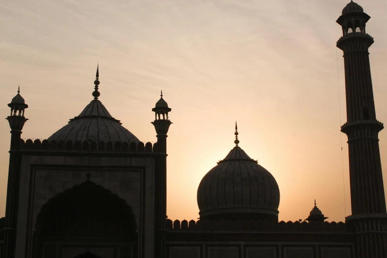 the sun is setting in the background of two large buildings