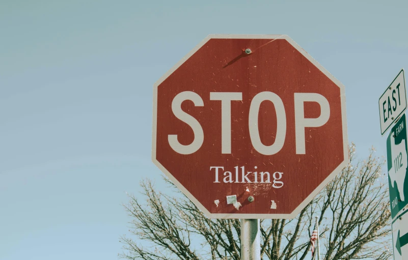 an image of stop sign with graffiti under it