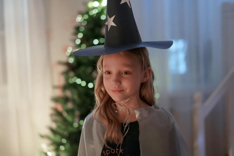 a little girl wearing a wizard's hat posing for a po