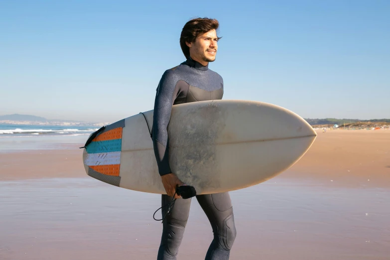 a man holding a surfboard walking out of the ocean