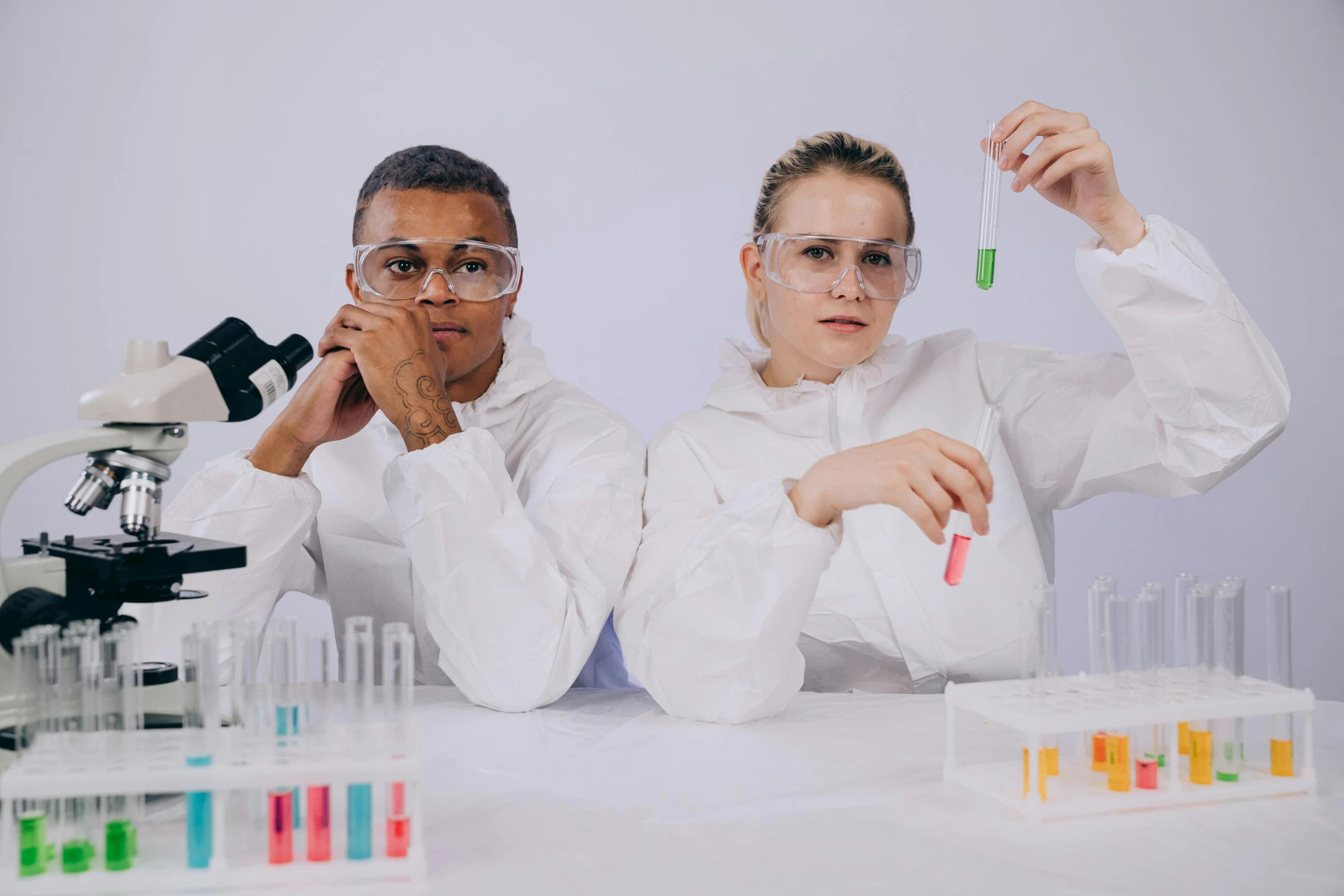 a couple of people sitting at a table with laboratory equipment