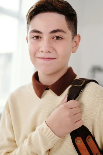 a  wearing a brown sweater and a small brown bow tie
