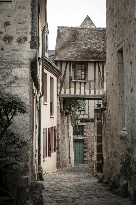 an old stone building with a green door on a cobble stone walkway