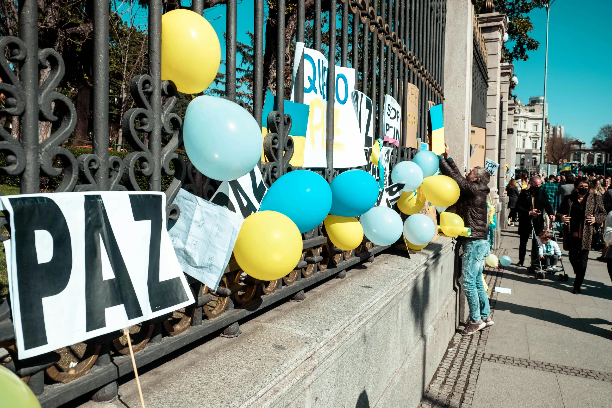 a number of balloons are hanging from a fence