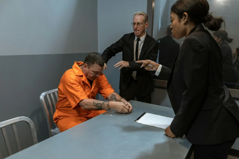 two people sit at the table, one in an orange shirt