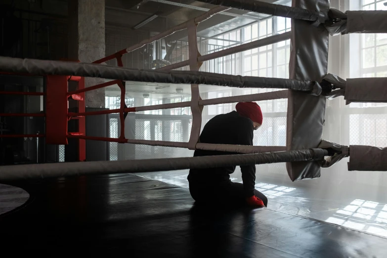 a boy plays inside a boxing ring and prepares to fight