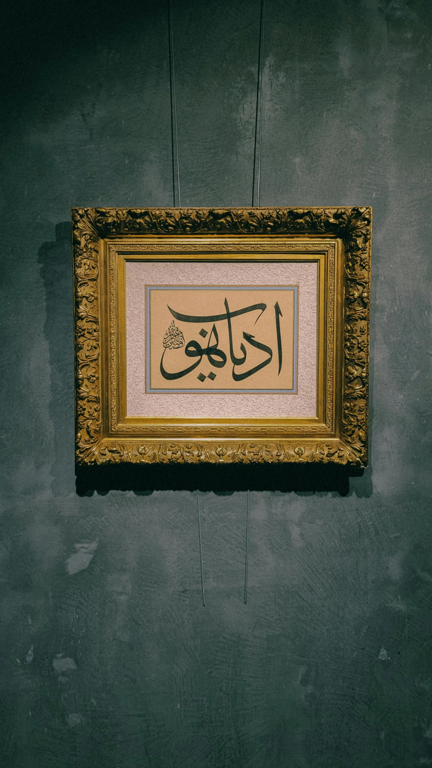 a framed arabic letter is hanging on the wall