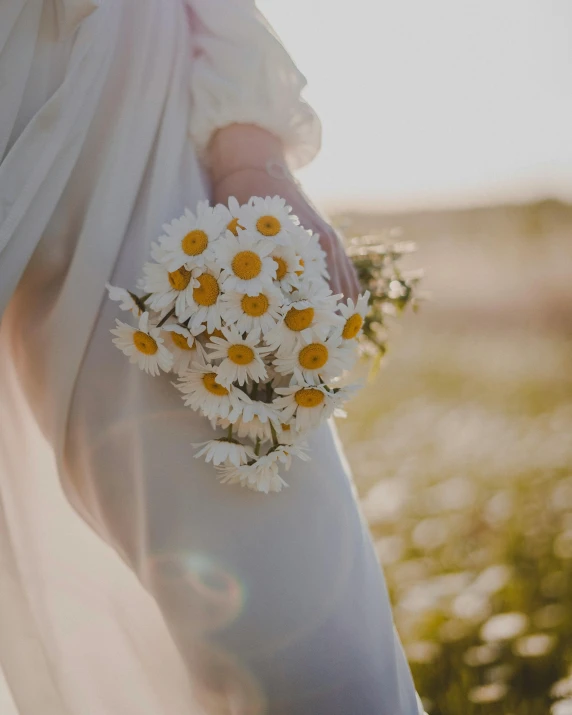 a brides bouquet with white daisies is ready for the ceremony