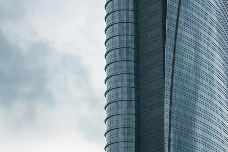 two tall glass buildings are in front of a cloudy sky