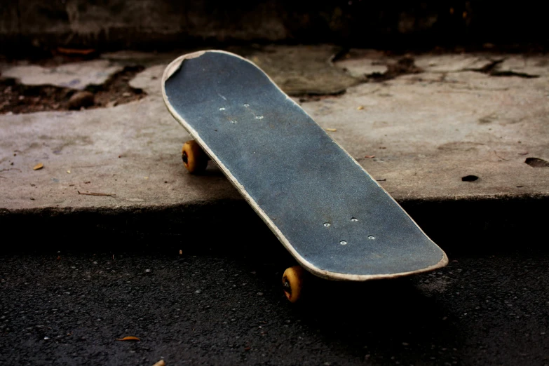 a skateboard sitting on the sidewalk in front of some bricks