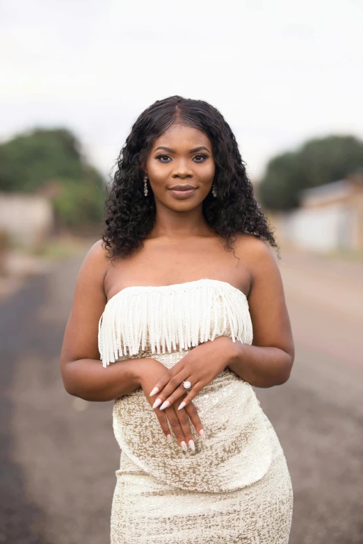 woman in white dress standing on the road smiling