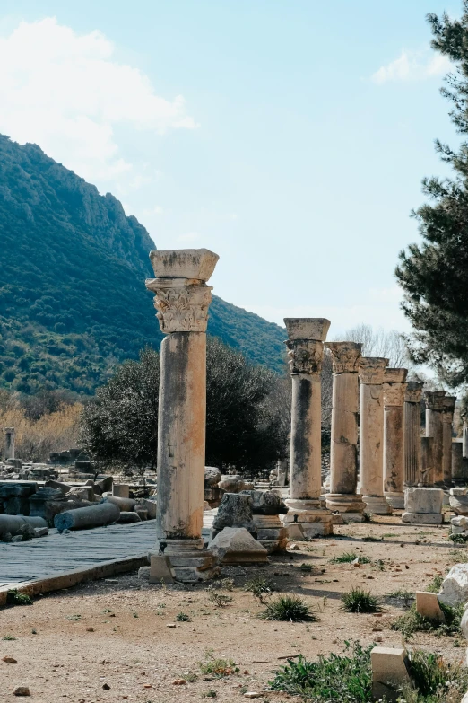 stone columns line the street beside some mountains