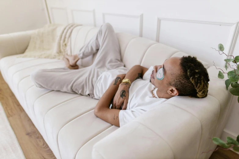 man with dreadlocks laying on a couch